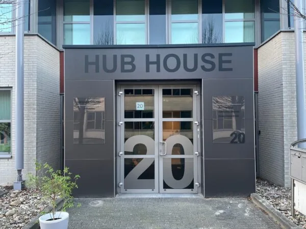 Ingang van het kantoorgebouw HUB HOUSE met huisnummer 20 op de deur.